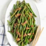 Green beans with bacon on a white platter ready to enjoy