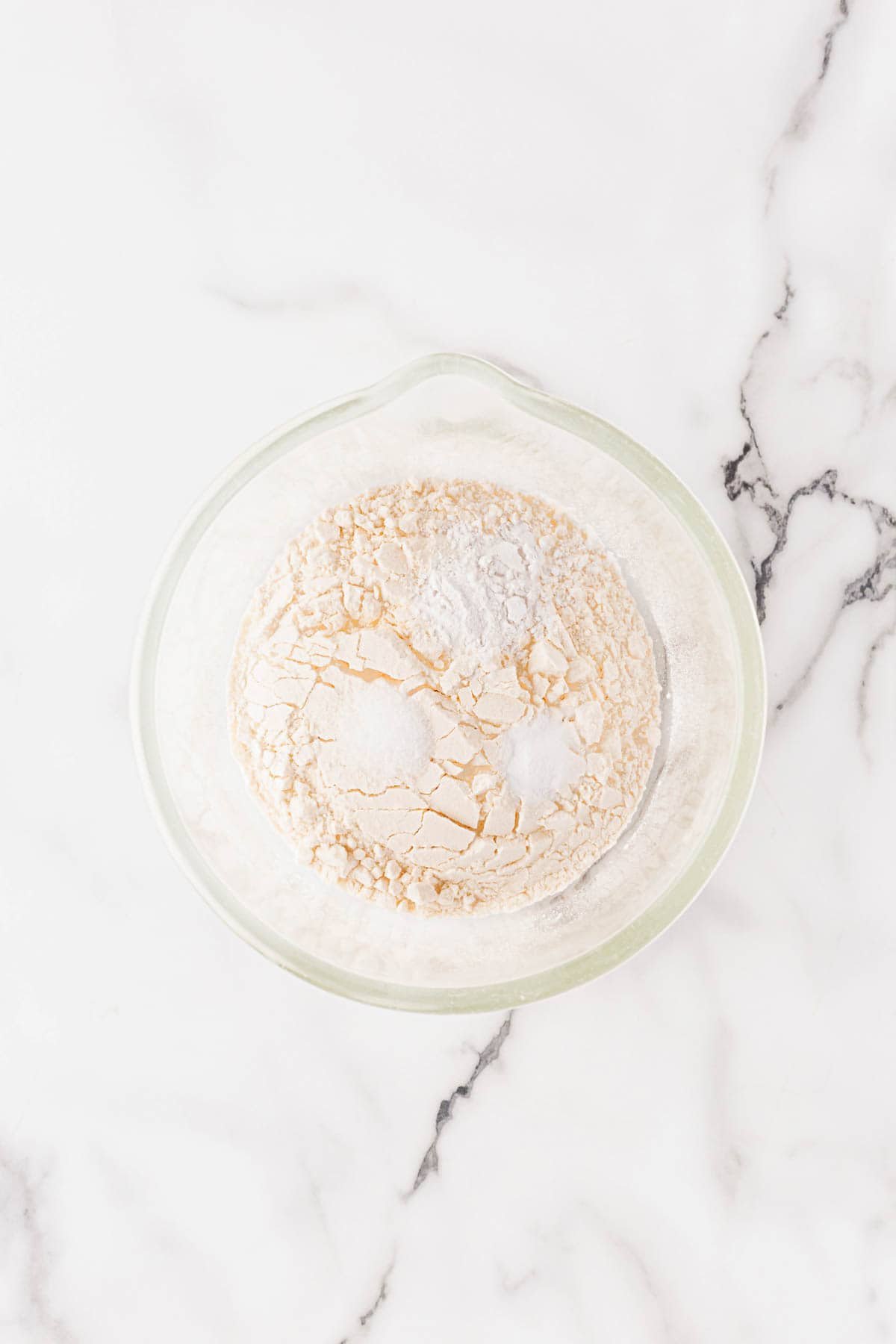 Mixing bowl filled with dry ingredients like flour, baking powder, and salt, ready to be combined