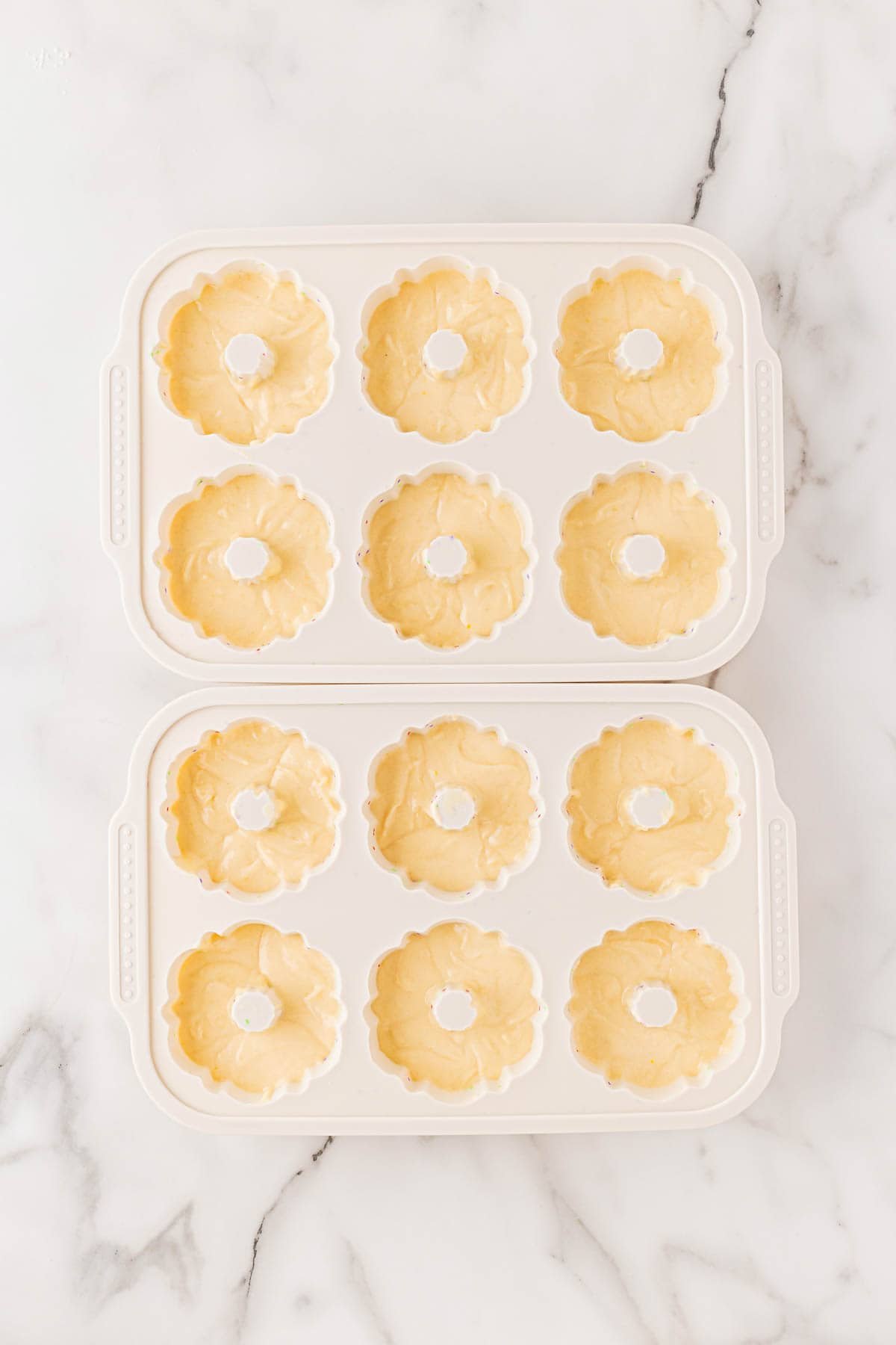 Mini honey bundt cakes batter evenly portioned in a white silicone mold before baking
