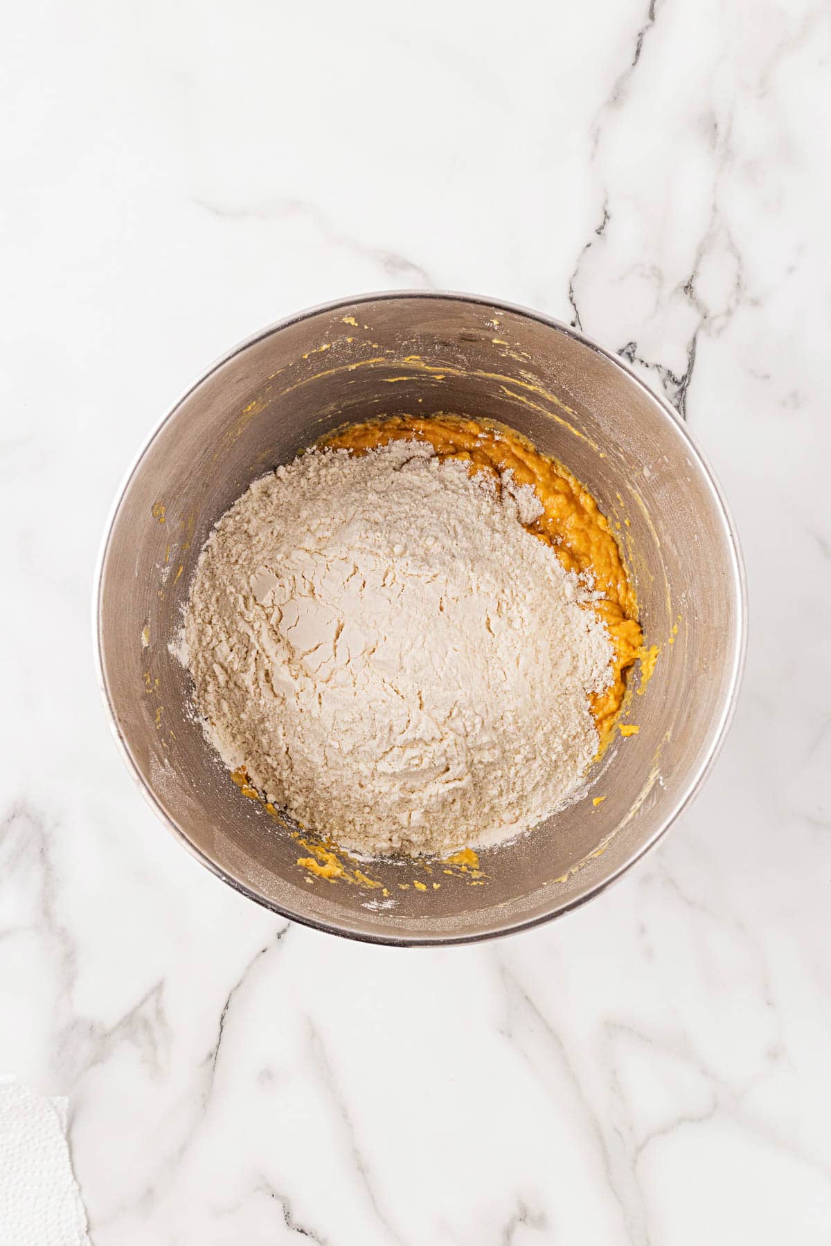 Mixing bowl with additional flour added to pumpkin dough mixture