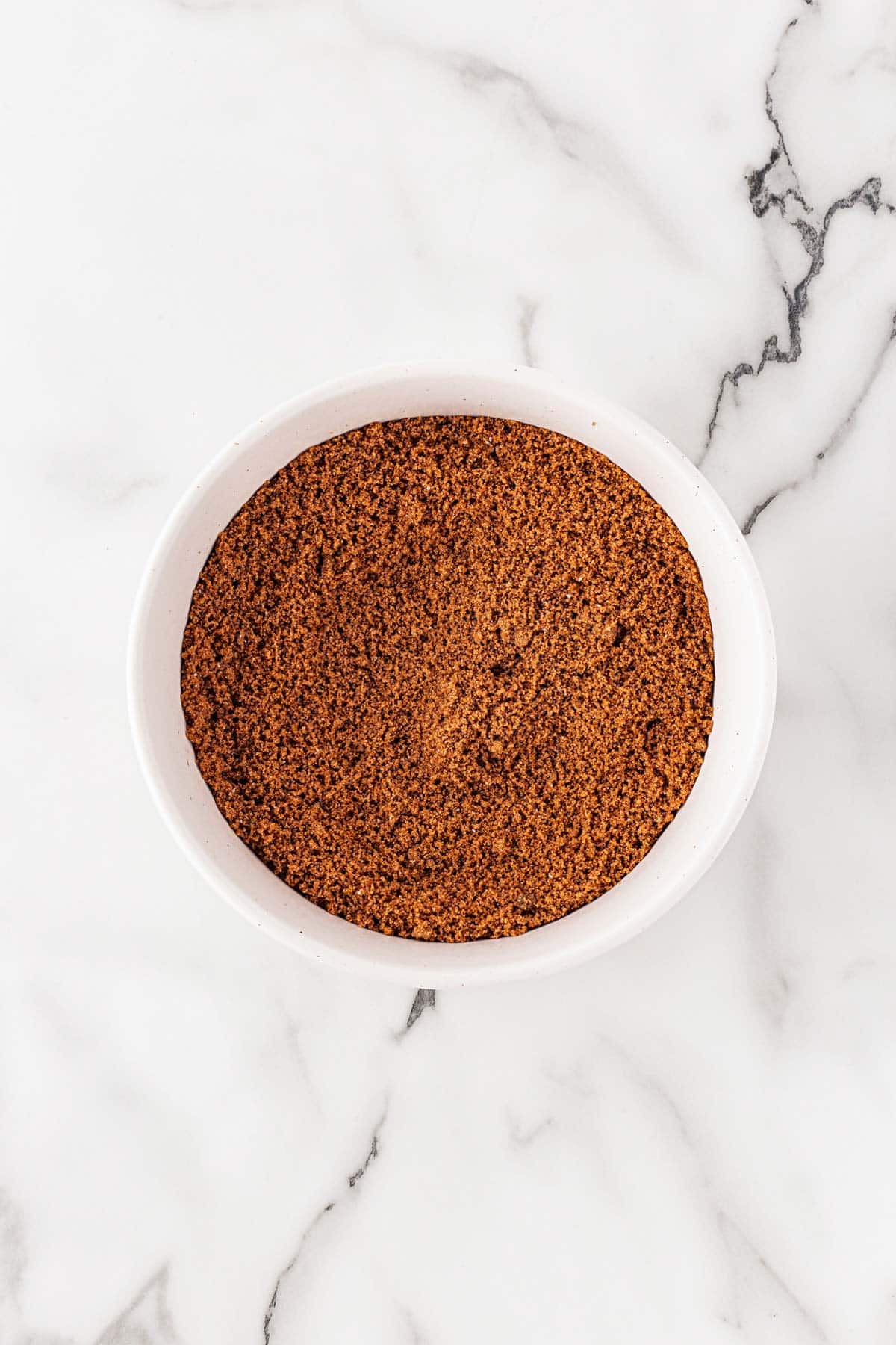 White bowl filled with brown sugar and cinnamon mixture for the filling
