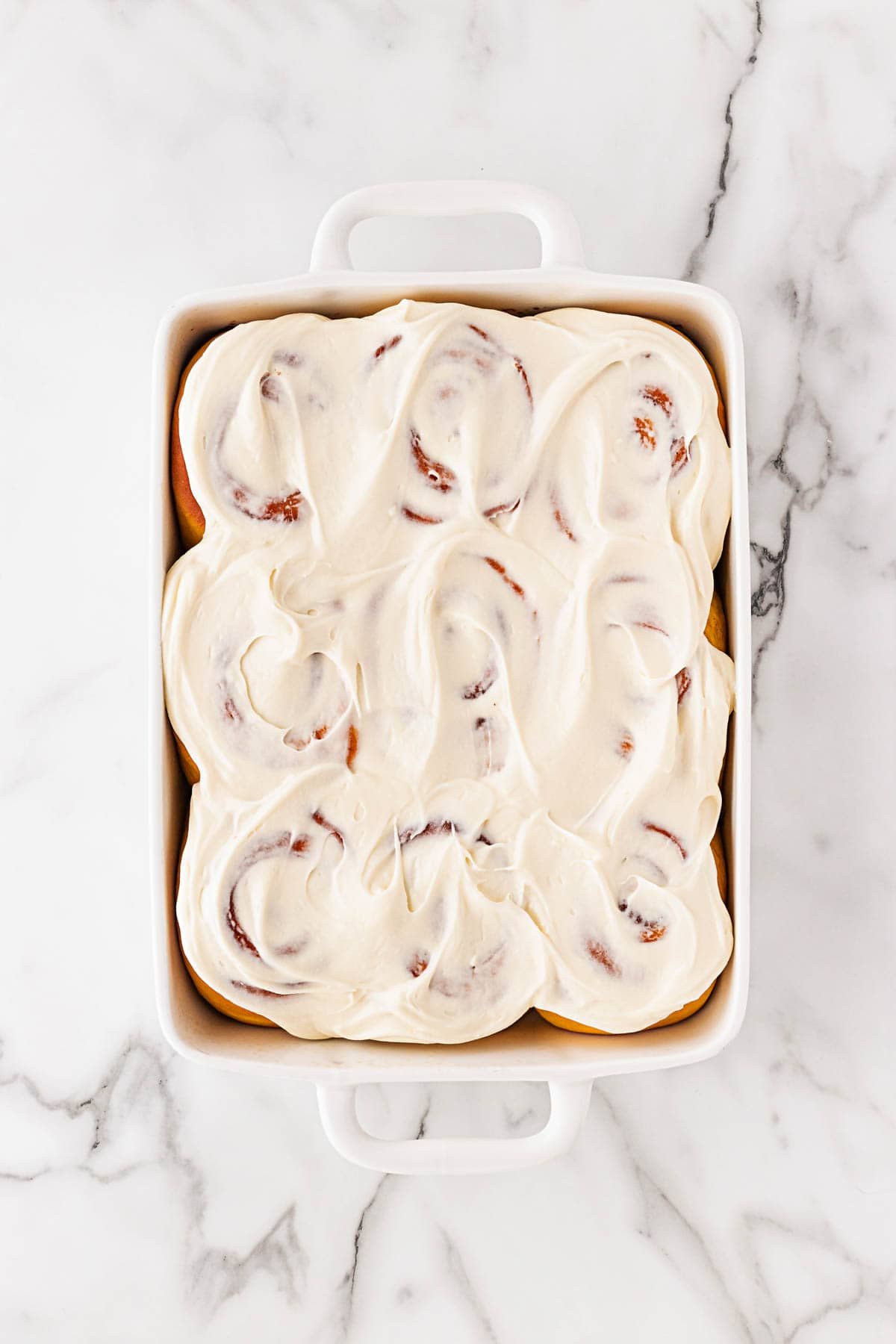 Baked pumpkin cinnamon rolls covered generously with thick cream cheese frosting