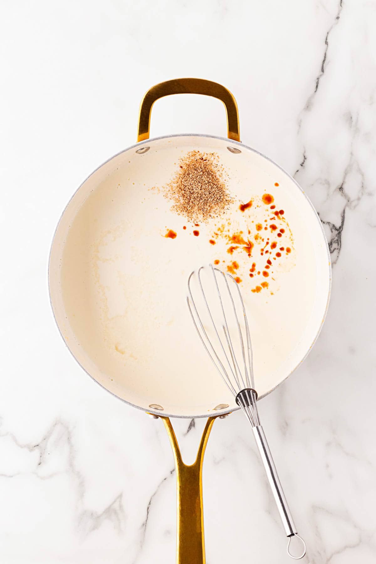 Skillet with bechamel sauce and spices