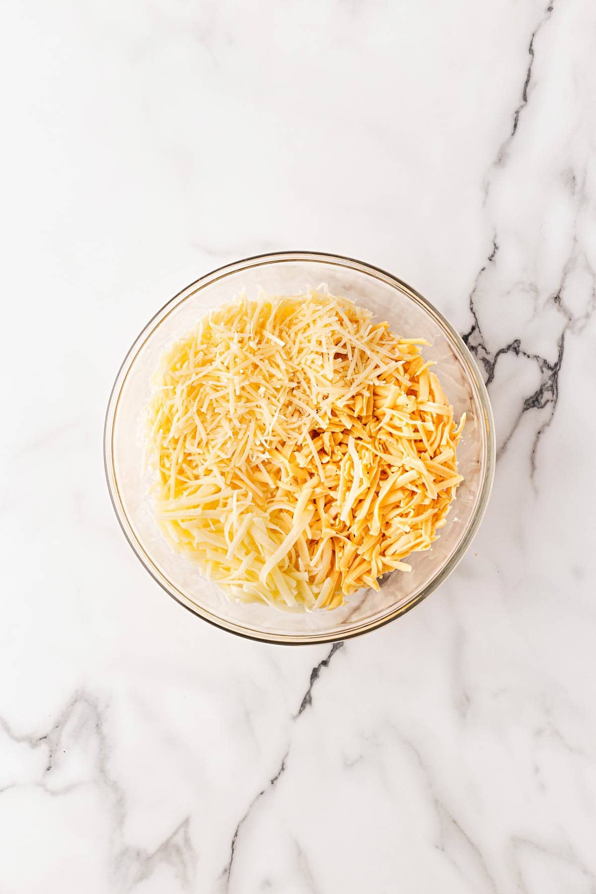 Bowl filled with a blend of shredded cheeses including mozzarella, cheddar, and parmesan