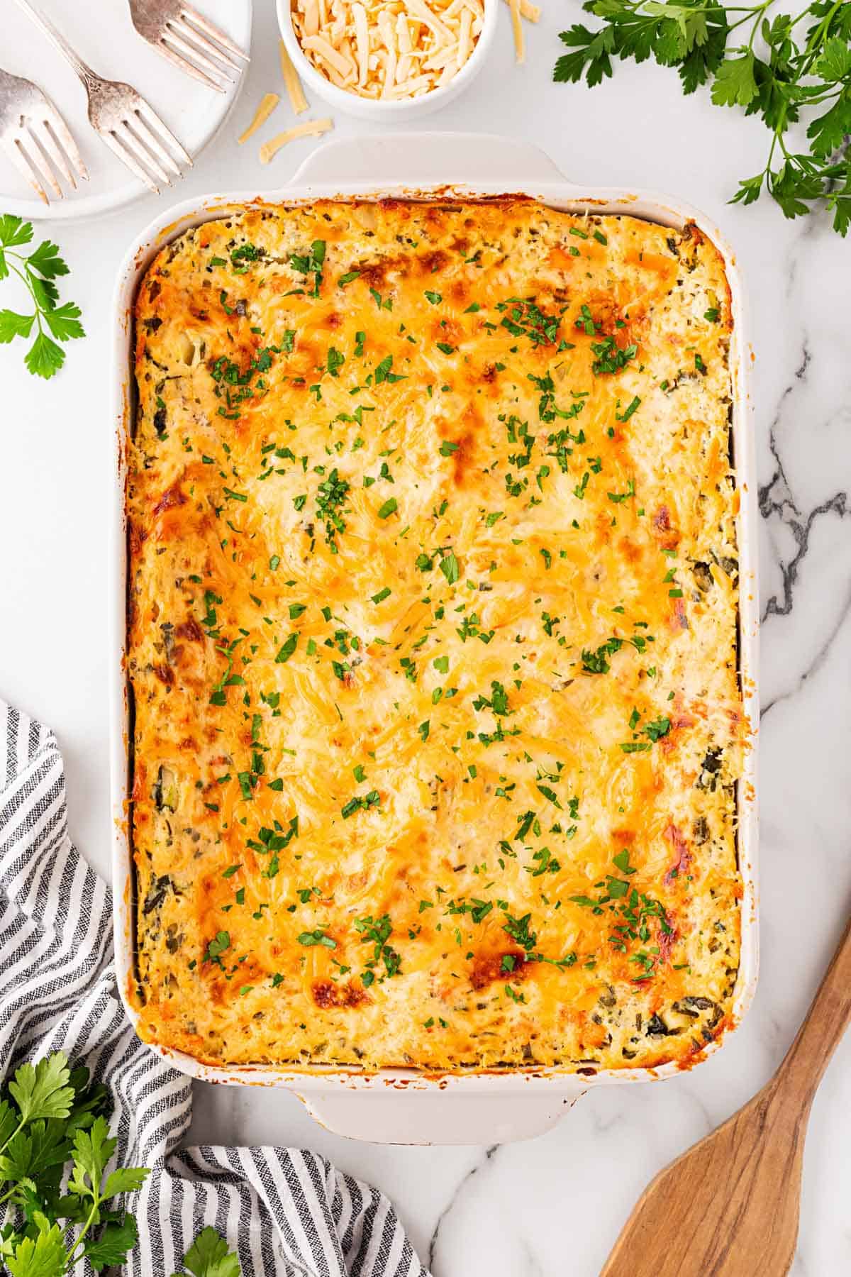 Overhead shot of baked seafood lasagna with a golden, bubbly cheese topping garnished with fresh parsley