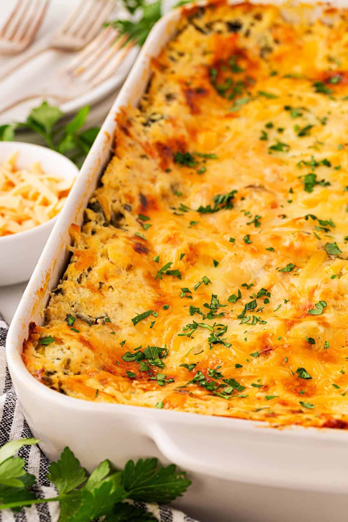 Side view of the baked seafood lasagna in the dish, showing the golden top layer and creamy edges