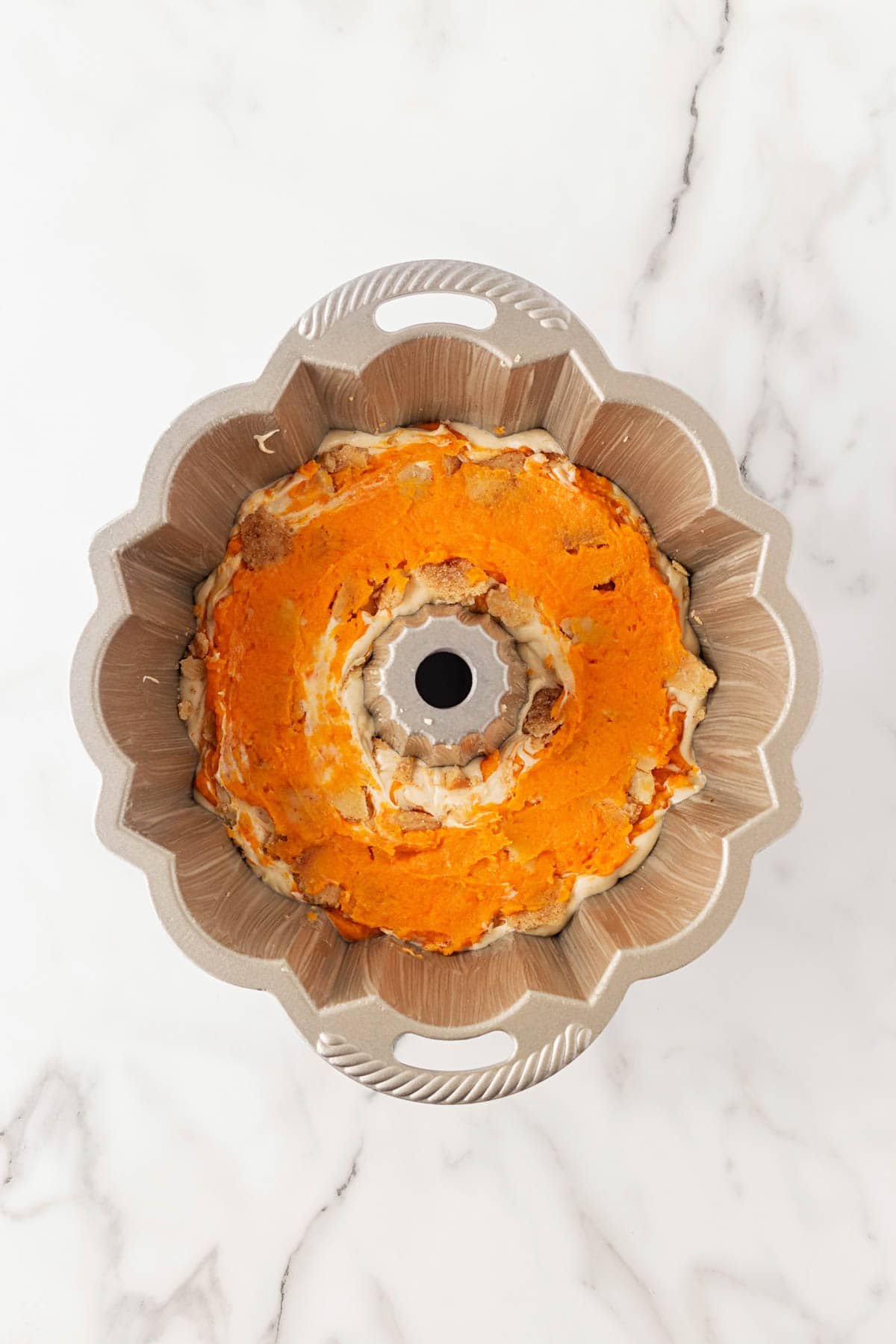 Bundt pan with a layer of sweet potato mixture spread evenly over the top of the batter