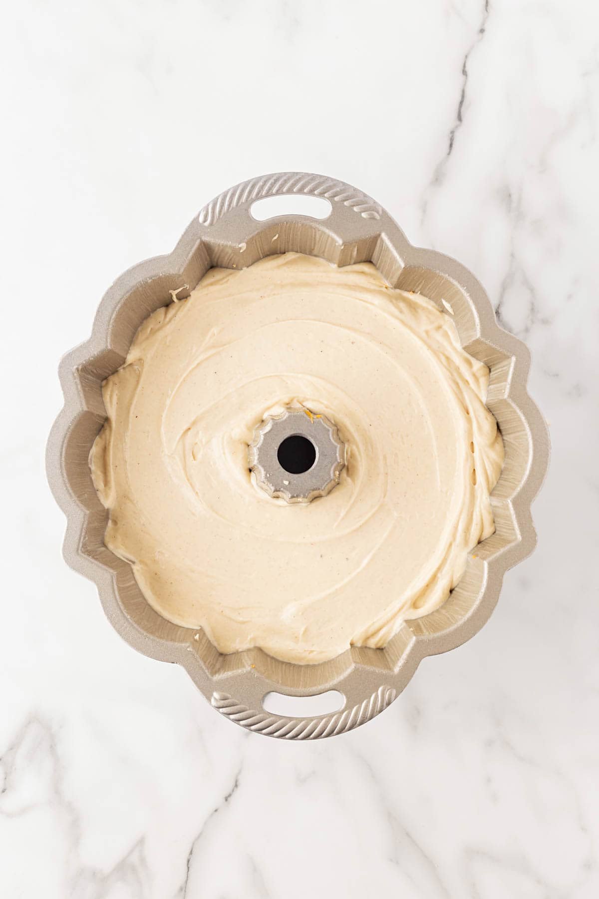 Bundt pan filled to the top with the final layer of cake batter, ready for baking