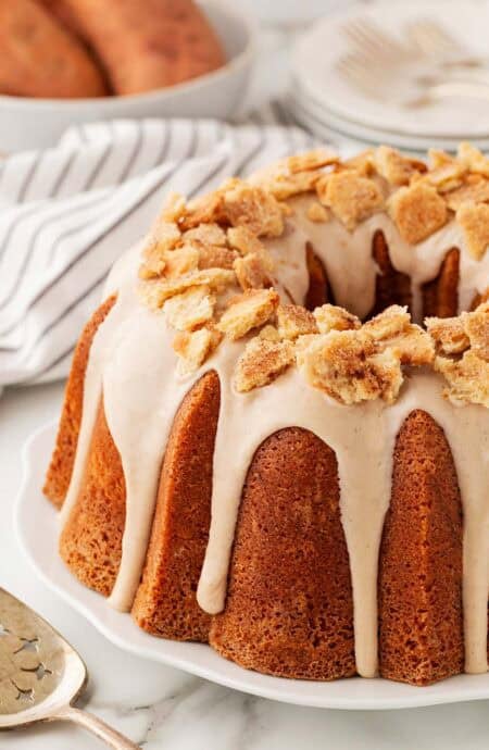 A glazed sweet potato pie pound cake topped with pie crust crumbles