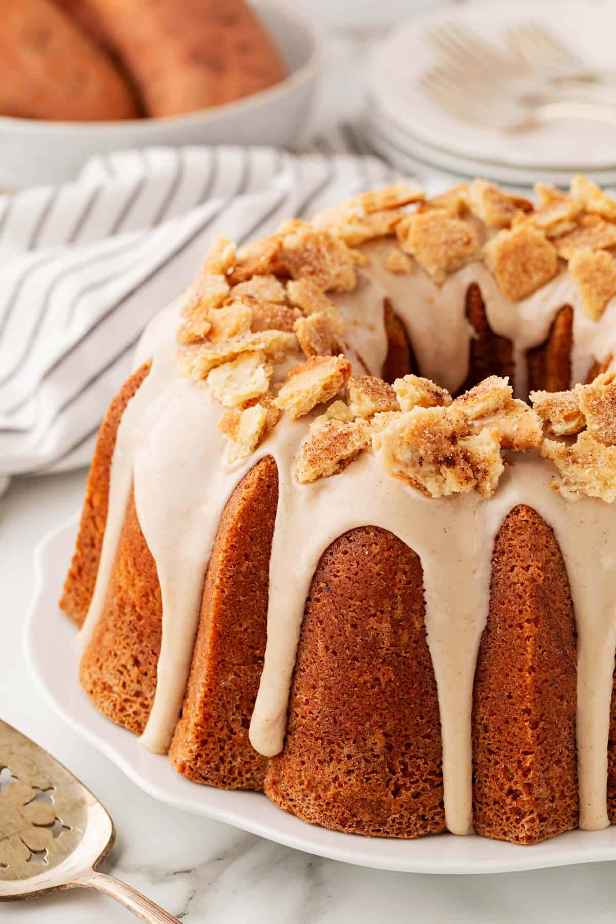 A glazed sweet potato pie pound cake topped with pie crust crumbles