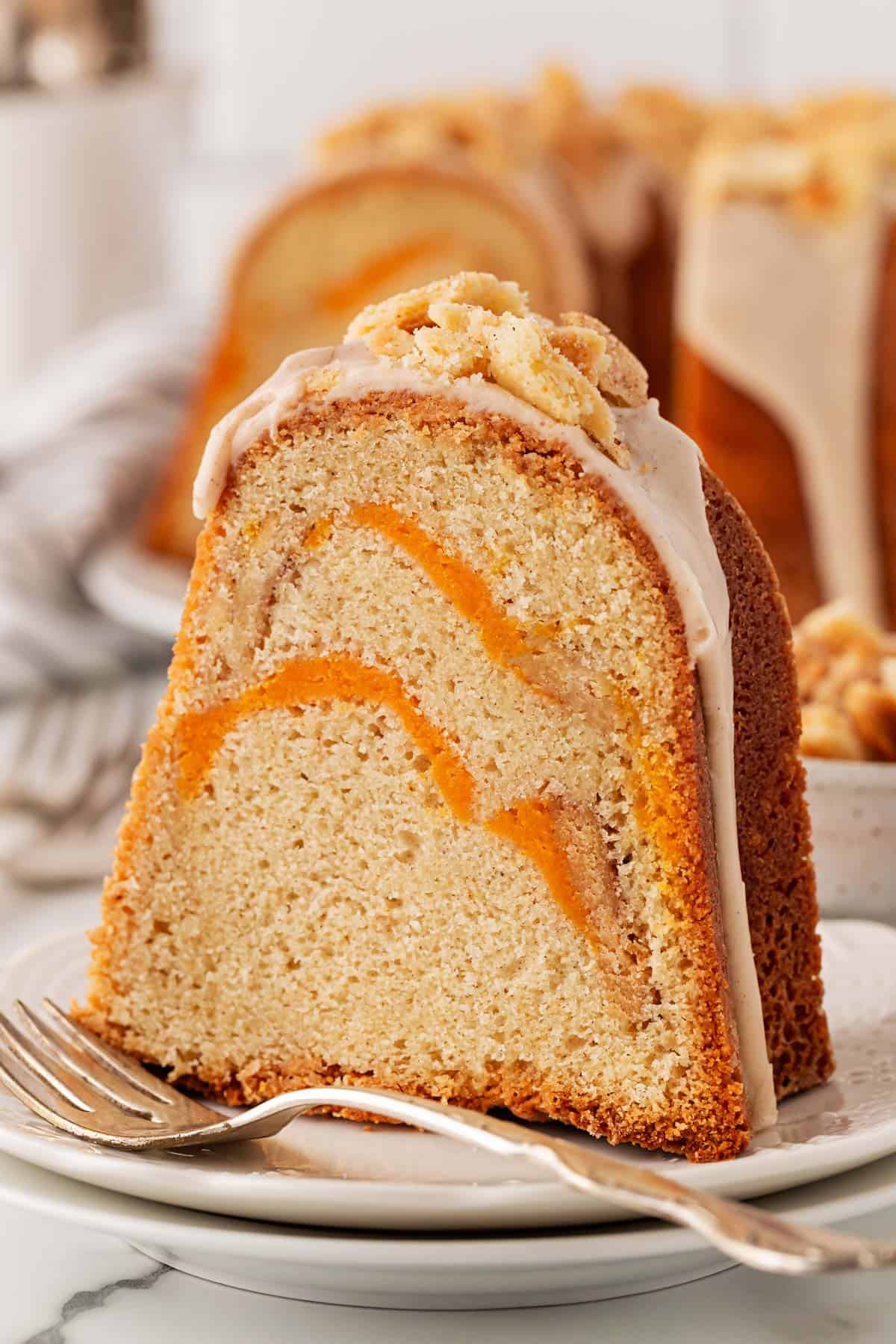 Close up of a single sweet potato pie pound cake slice showing the orange sweet potato swirl inside