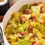 Large pot filled with fried cabbage and crispy bacon pieces