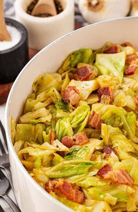 Large pot filled with fried cabbage and crispy bacon pieces