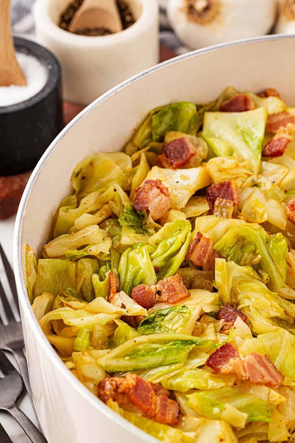 Large pot filled with fried cabbage and crispy bacon pieces