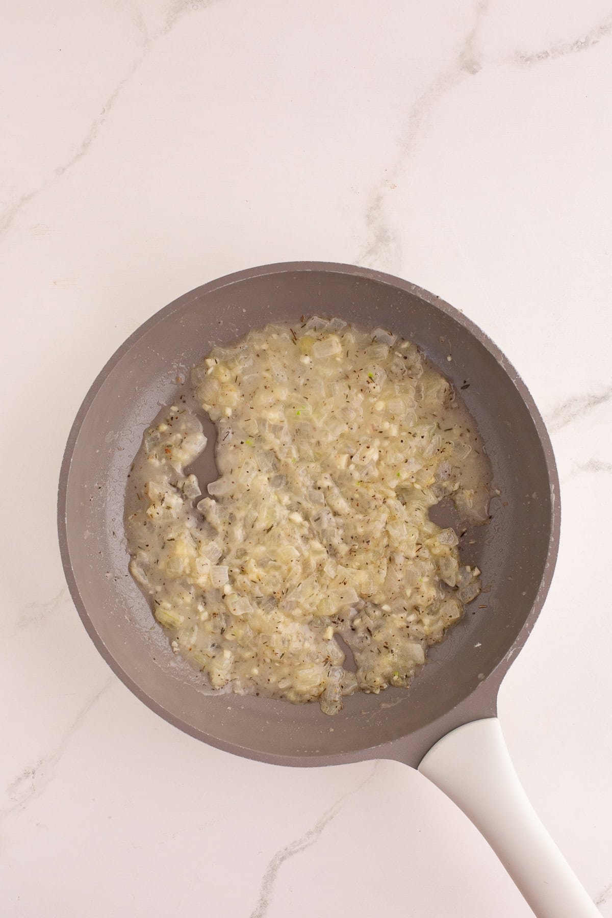 Sautéed onion and garlic mixture thickened in the skillet, forming the base for the sauce