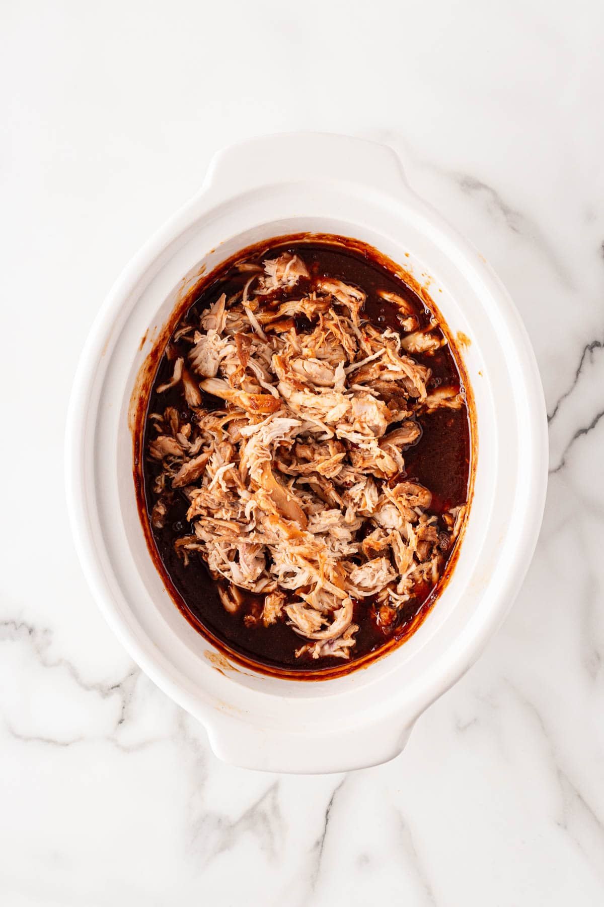 Shredded BBQ chicken added back into the slow cooker sauce