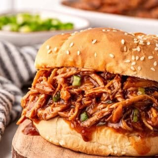 Barbeque shredded slow cooker chicken piled high on a sesame bun, ready to serve