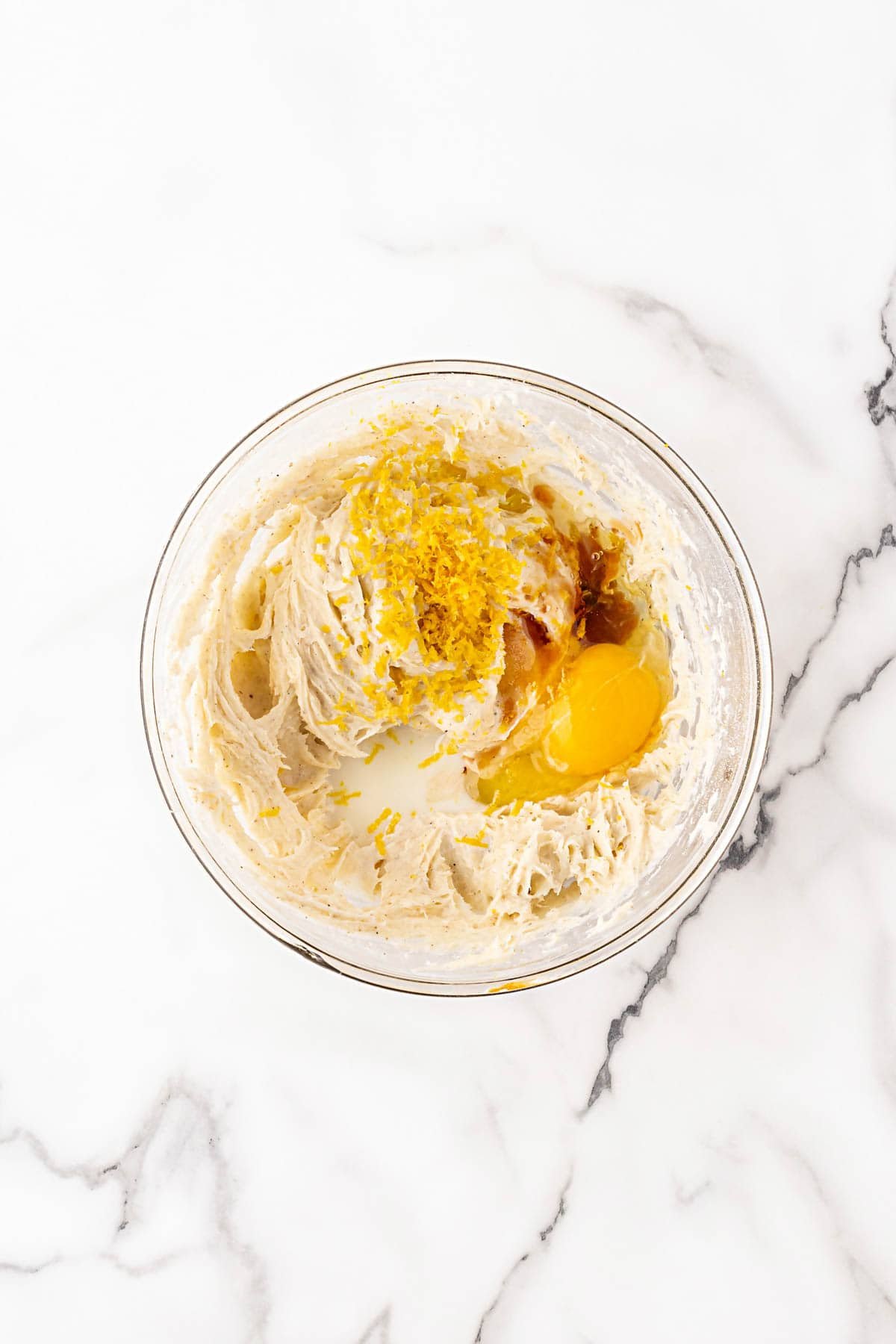 Bowl of creamy filling with egg yolk, vanilla, milk, and citrus zest before mixing