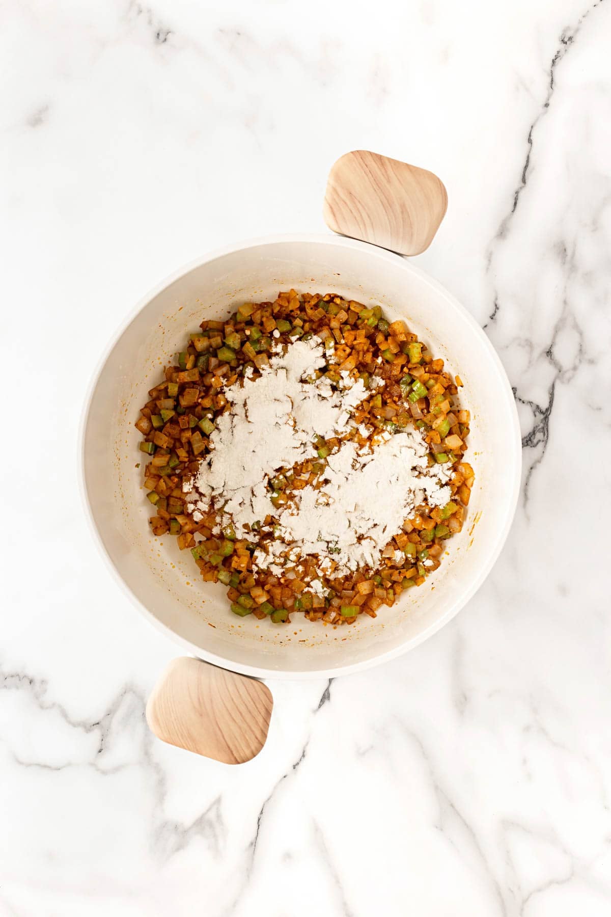 Flour added to the sautéed vegetables in the pot to form a thick base
