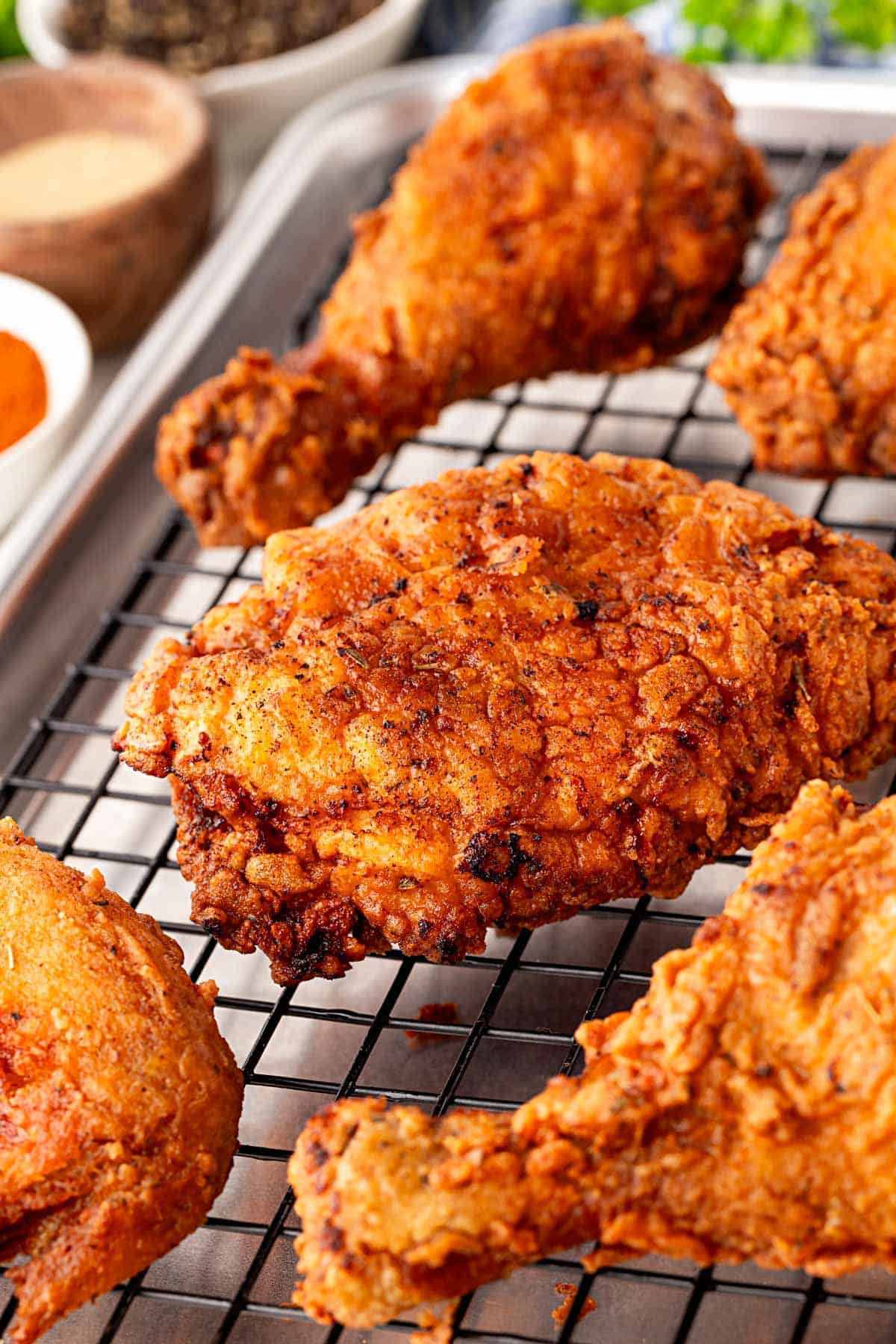 Closeup of crispy spicy fried chicken cooling in a wire rack