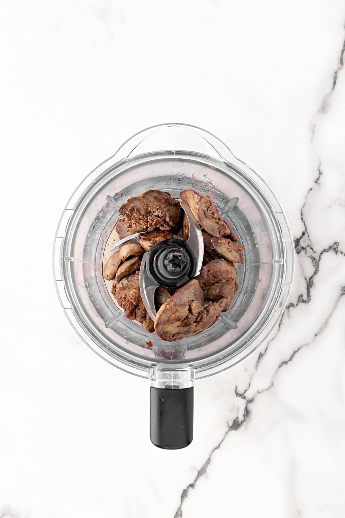 Cooked chicken livers placed in a food processor bowl