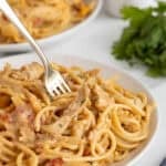 Creamy chicken spaghetti served on a plate with a fork