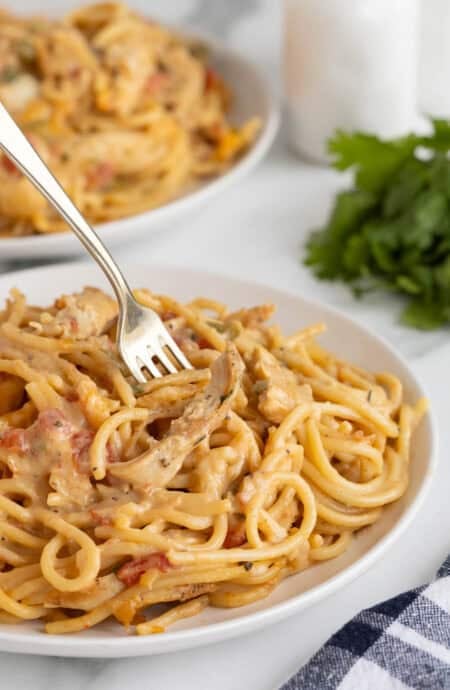 Creamy chicken spaghetti served on a plate with a fork