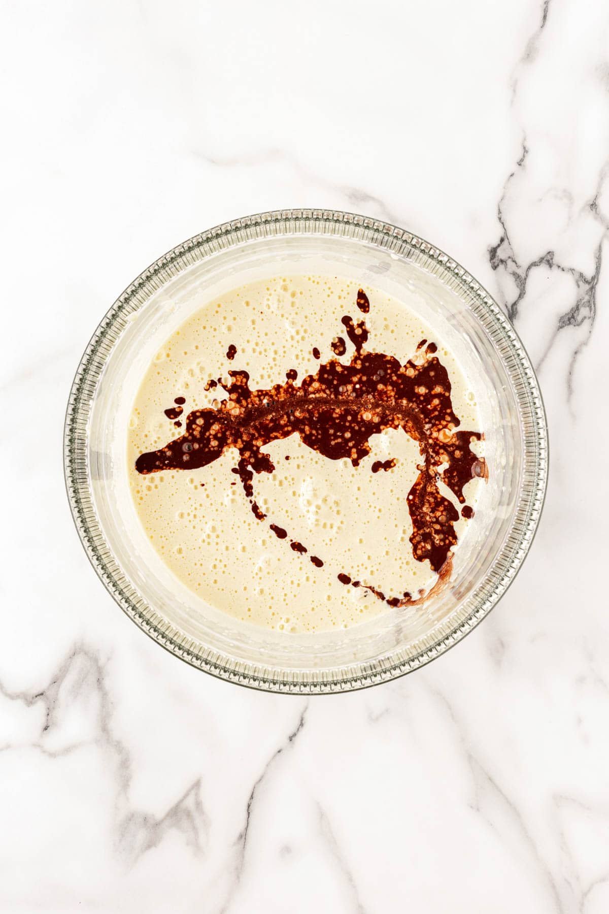 Cocoa and coffee mixture poured into a pale yellow egg mixture