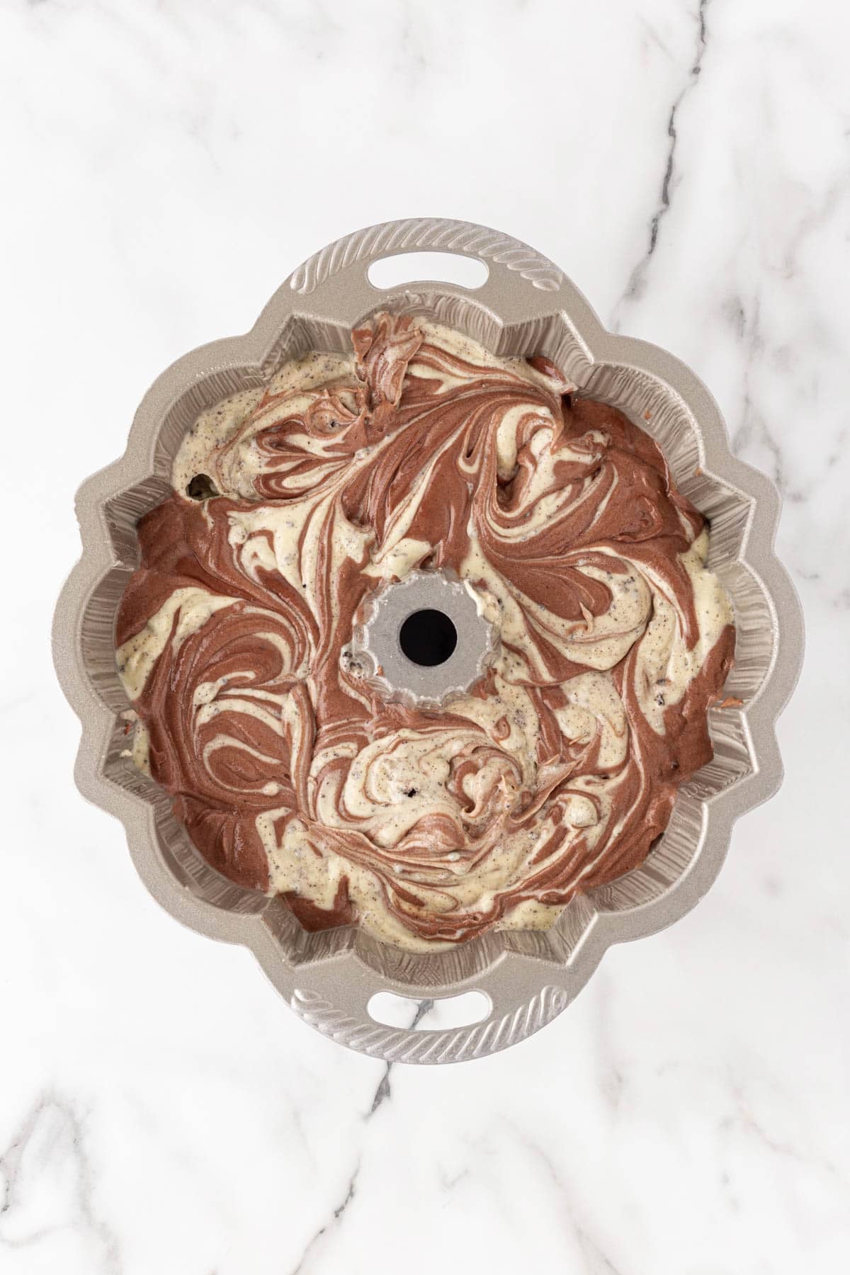Marbled chocolate and vanilla Oreo pound cake batter swirled in a Bundt pan