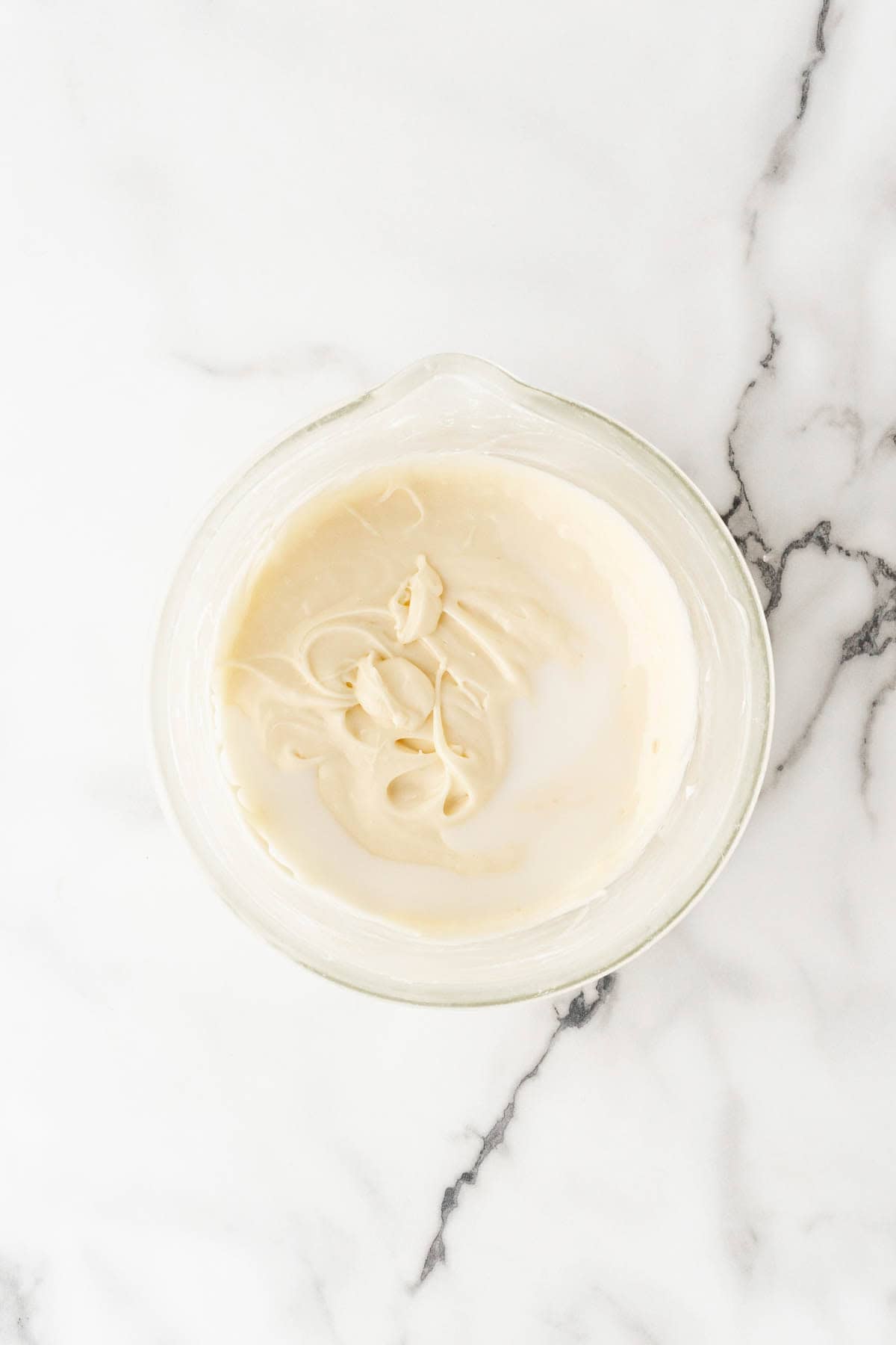 Smooth vanilla glaze mixture in a glass bowl