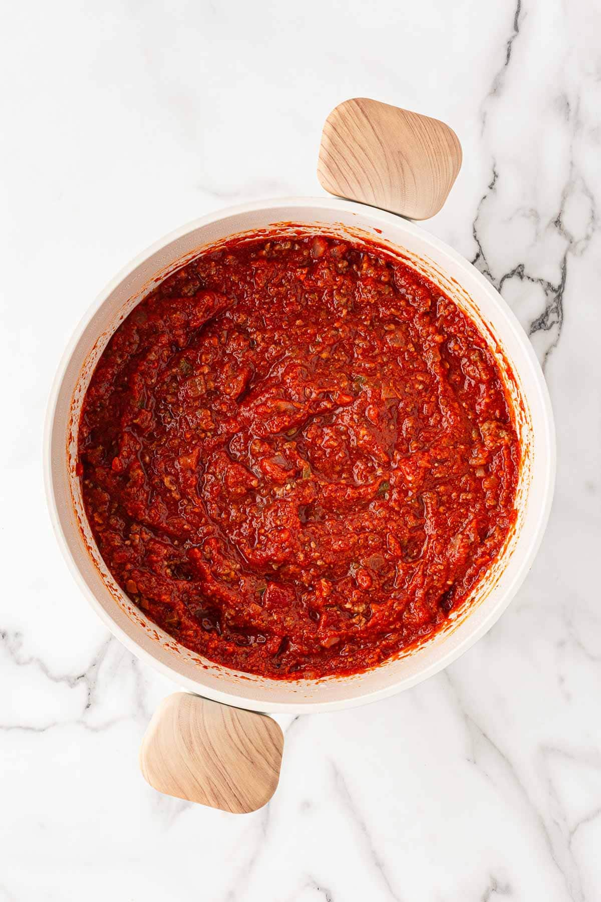Thick homemade meat sauce simmering in a skillet