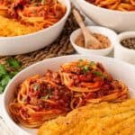 a white bowl with fish and spaghetti