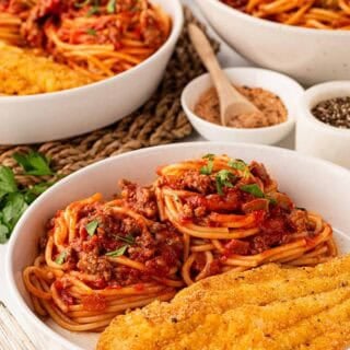 a white bowl with fish and spaghetti