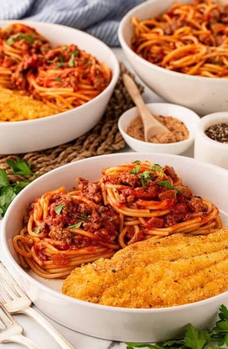 a white bowl with fish and spaghetti