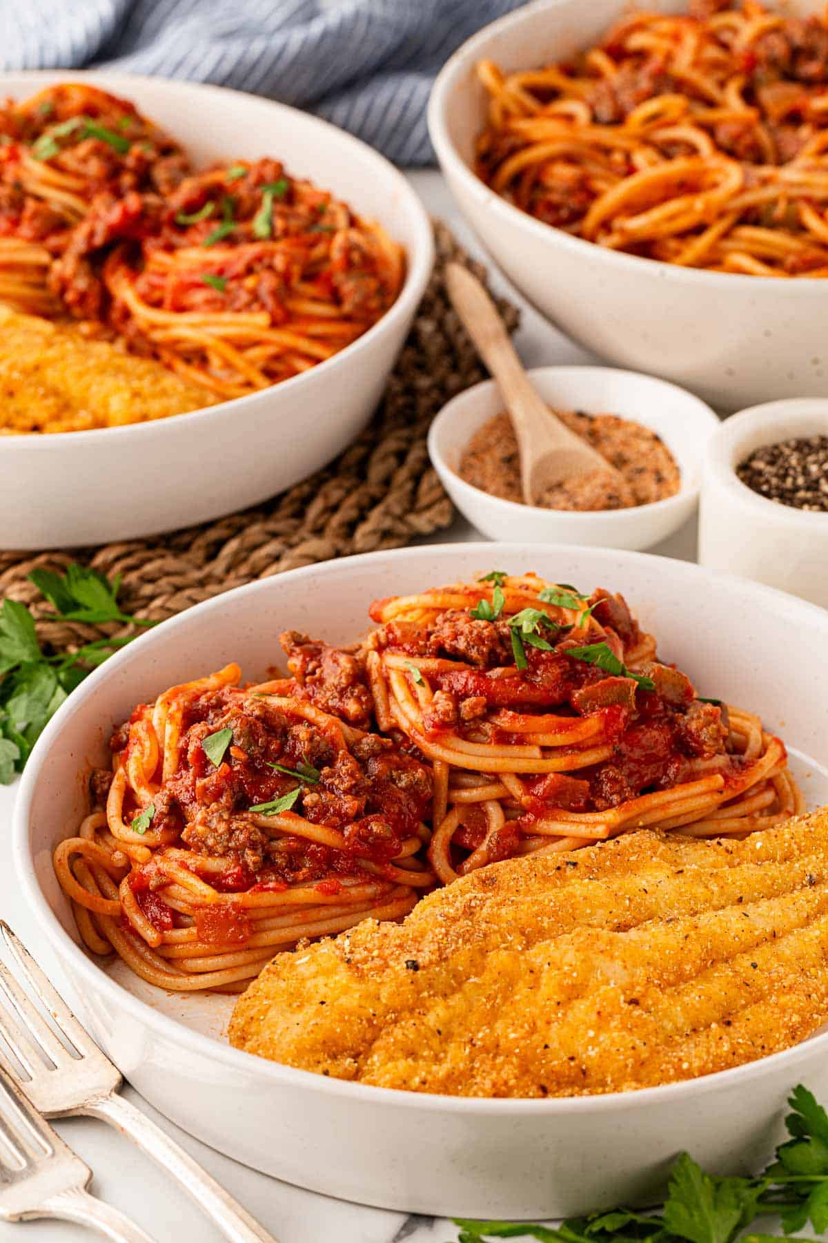 a white bowl with fish and spaghetti 