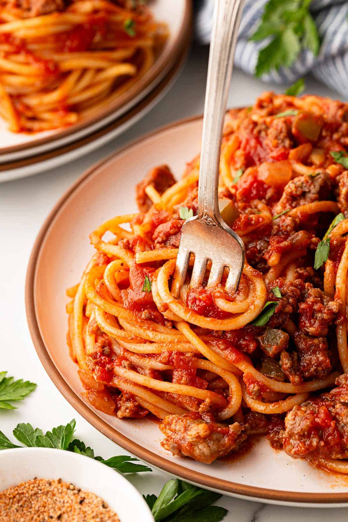 Fork twirling spaghetti with meat sauce on a plate