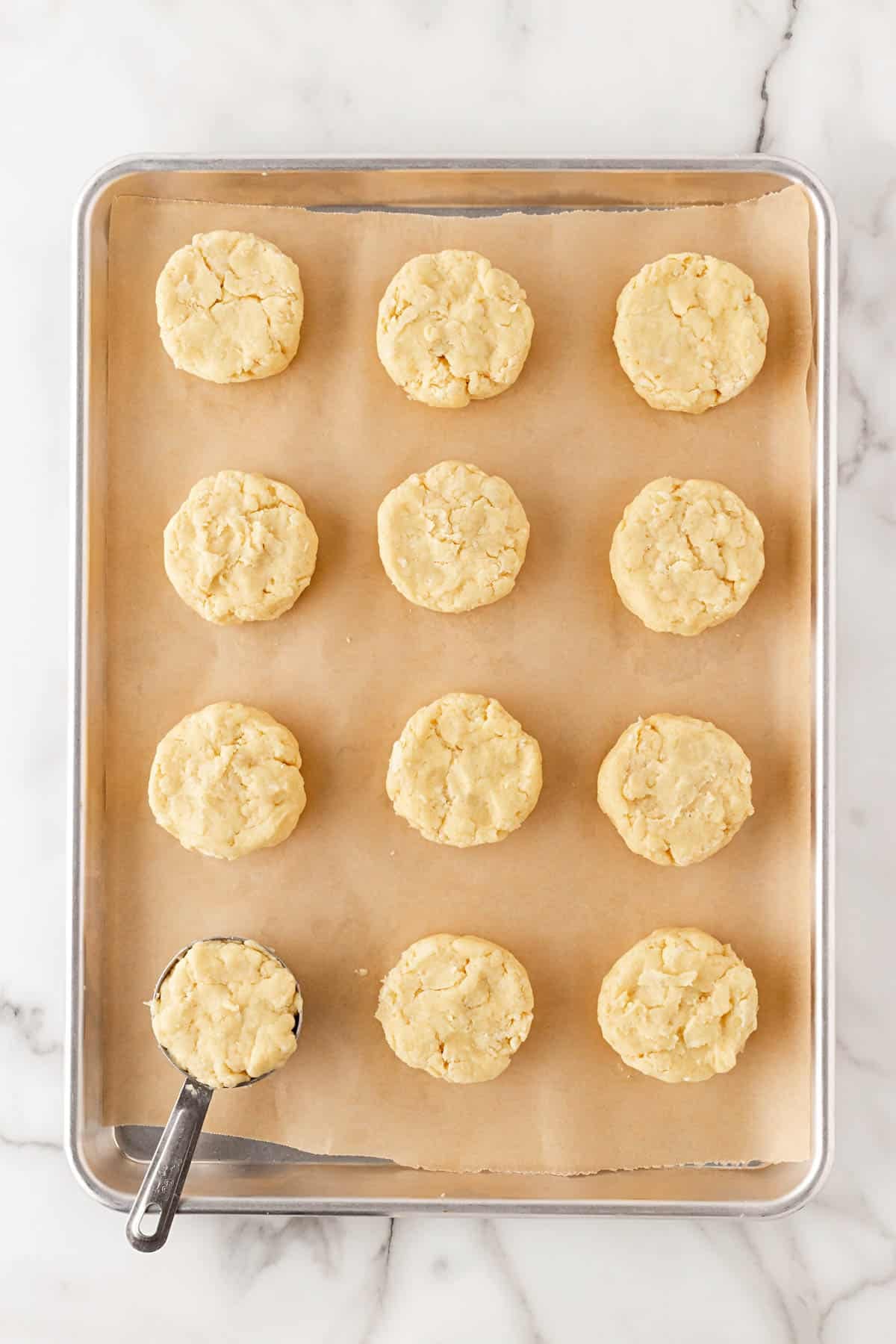Shortcake dough scooped onto a parchment-lined baking sheet