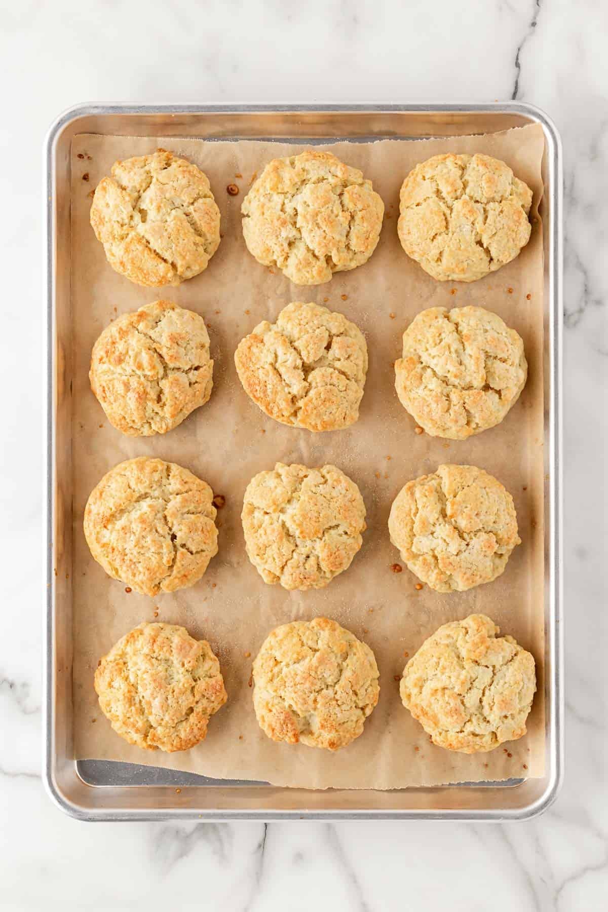 Freshly baked shortcakes golden brown on a parchment-lined pan