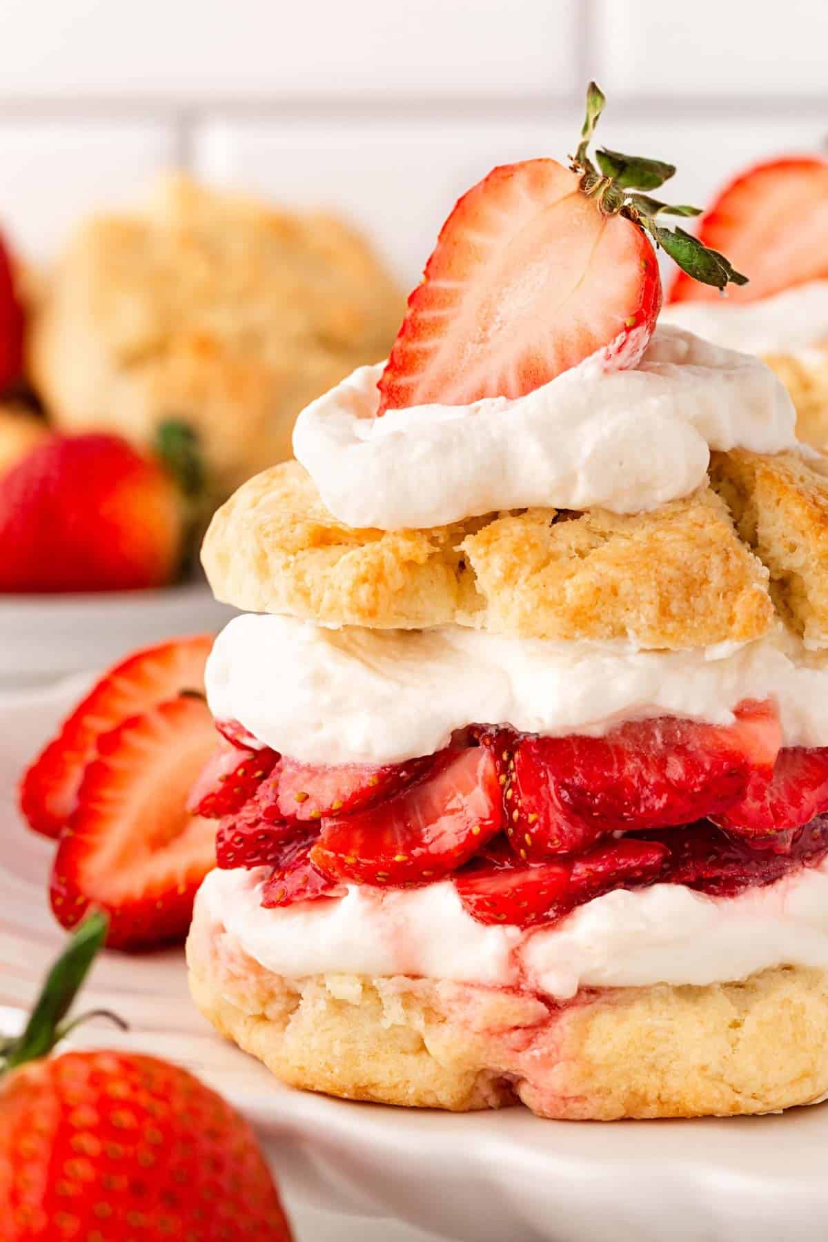 Closeup of strawberry shortcake layers with juicy strawberries and whipped cream