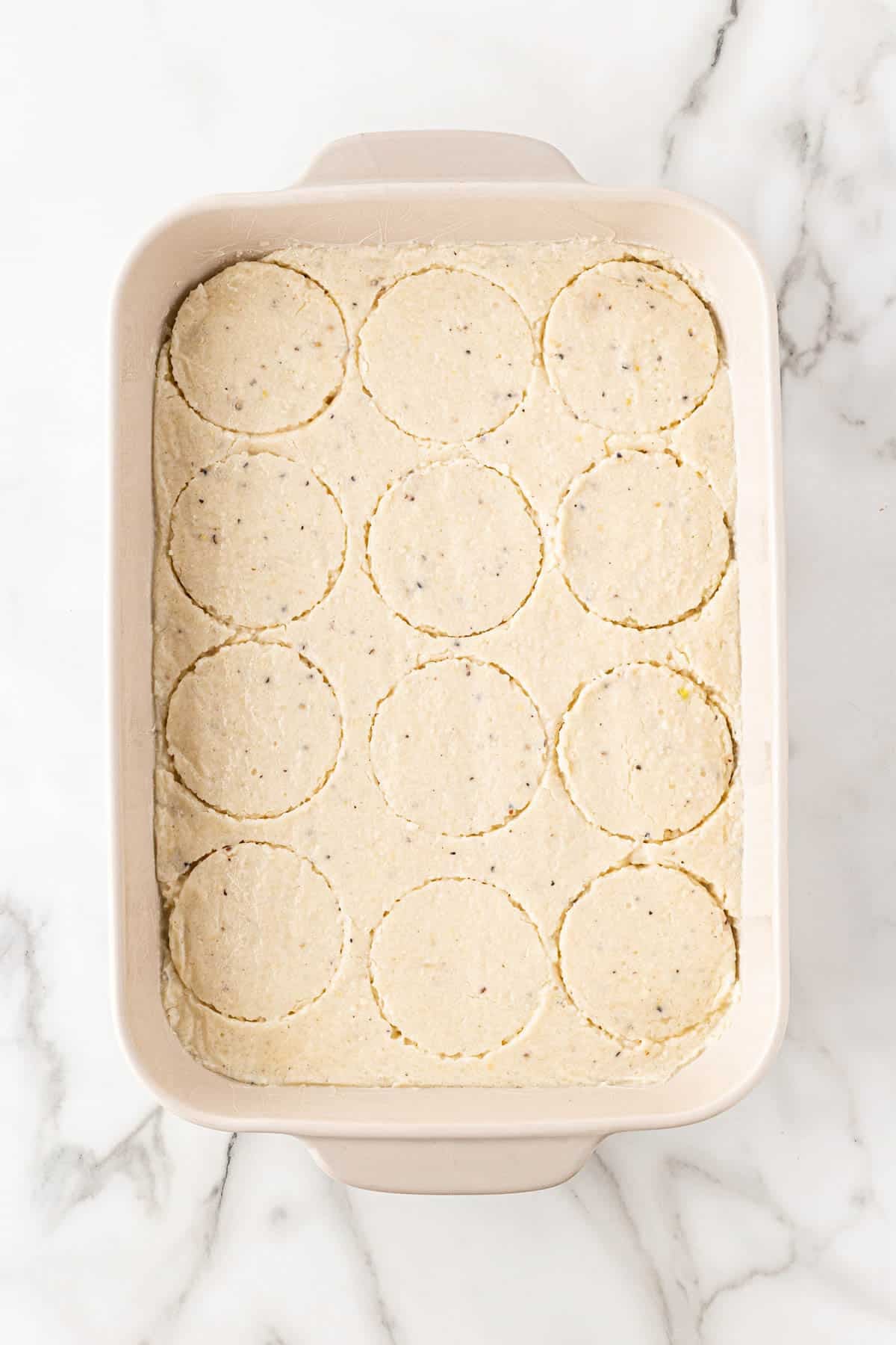 Grit slab cut into round shapes in a baking dish