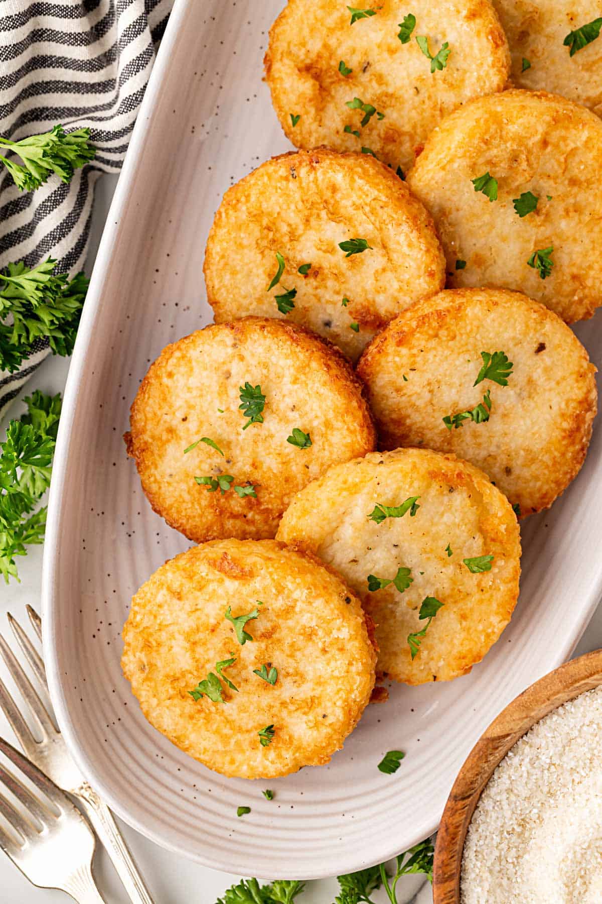 Platter of golden grit cakes garnished with parsley