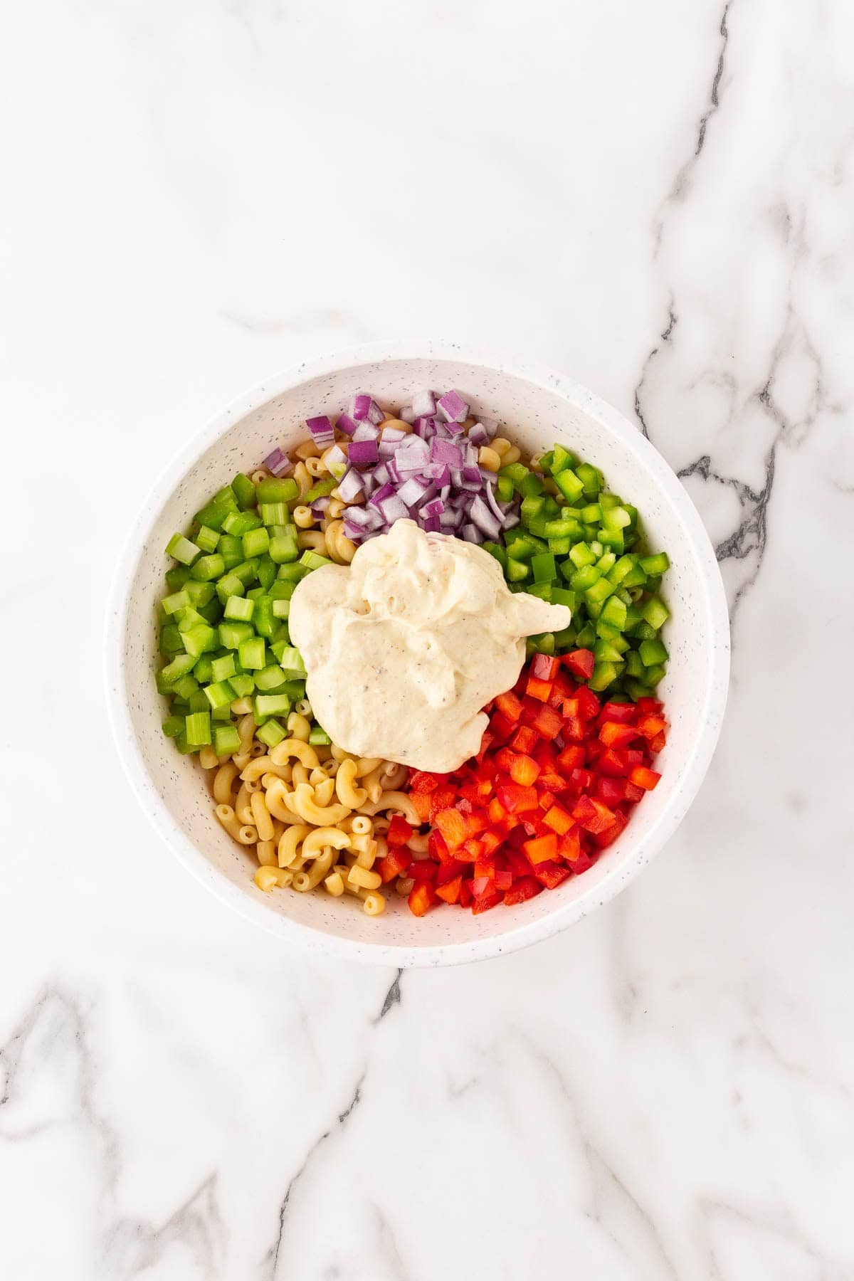 Macaroni with chopped celery, peppers, and onions topped with dressing
