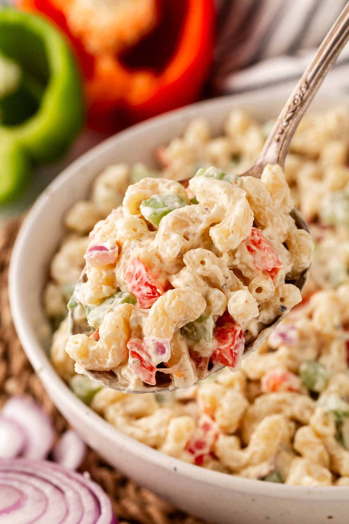 Spoonful of creamy macaroni salad with peppers and onions
