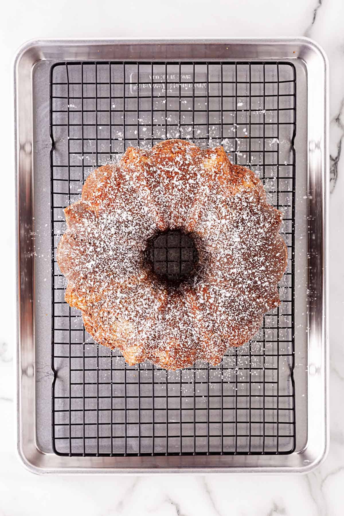 Neapolitan pound cake dusted with powdered sugar on a cooling rack