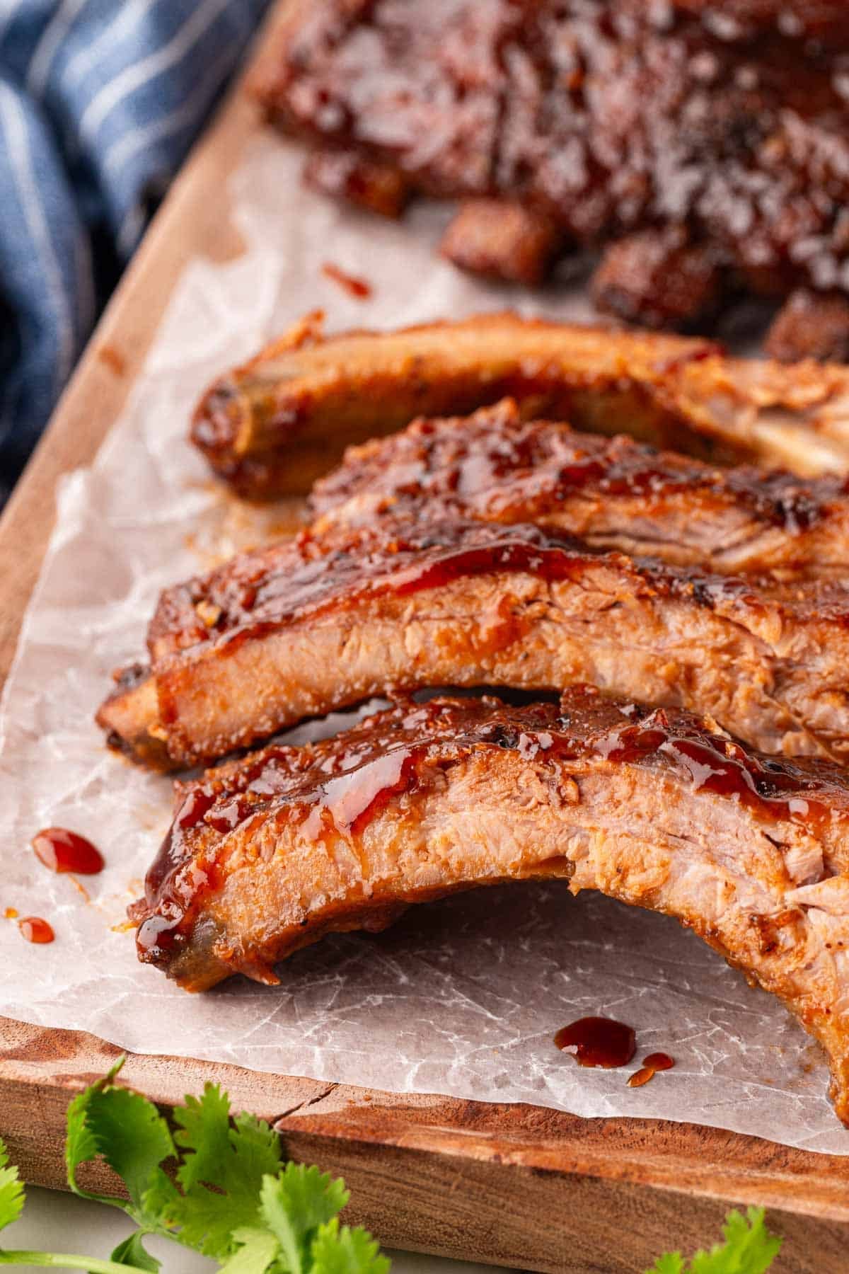 Closeup of sliced oven baked ribs with barbecue sauce and visible tender meat
