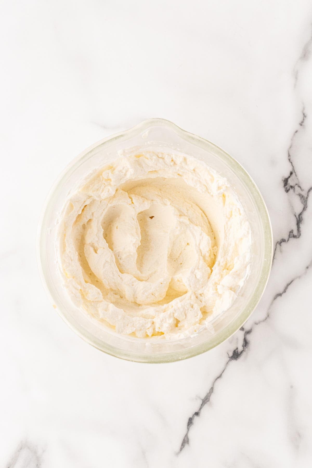 Bowl of whipped cream mixture for peach tiramisu topping