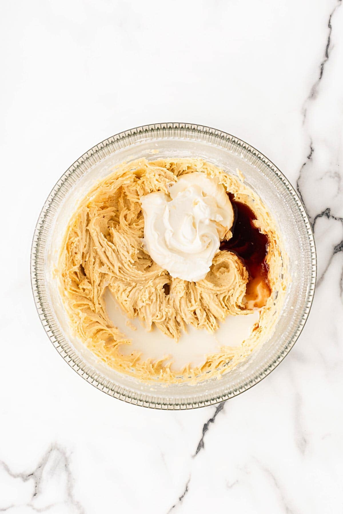 Batter mixed with sour cream, milk, and vanilla in bowl