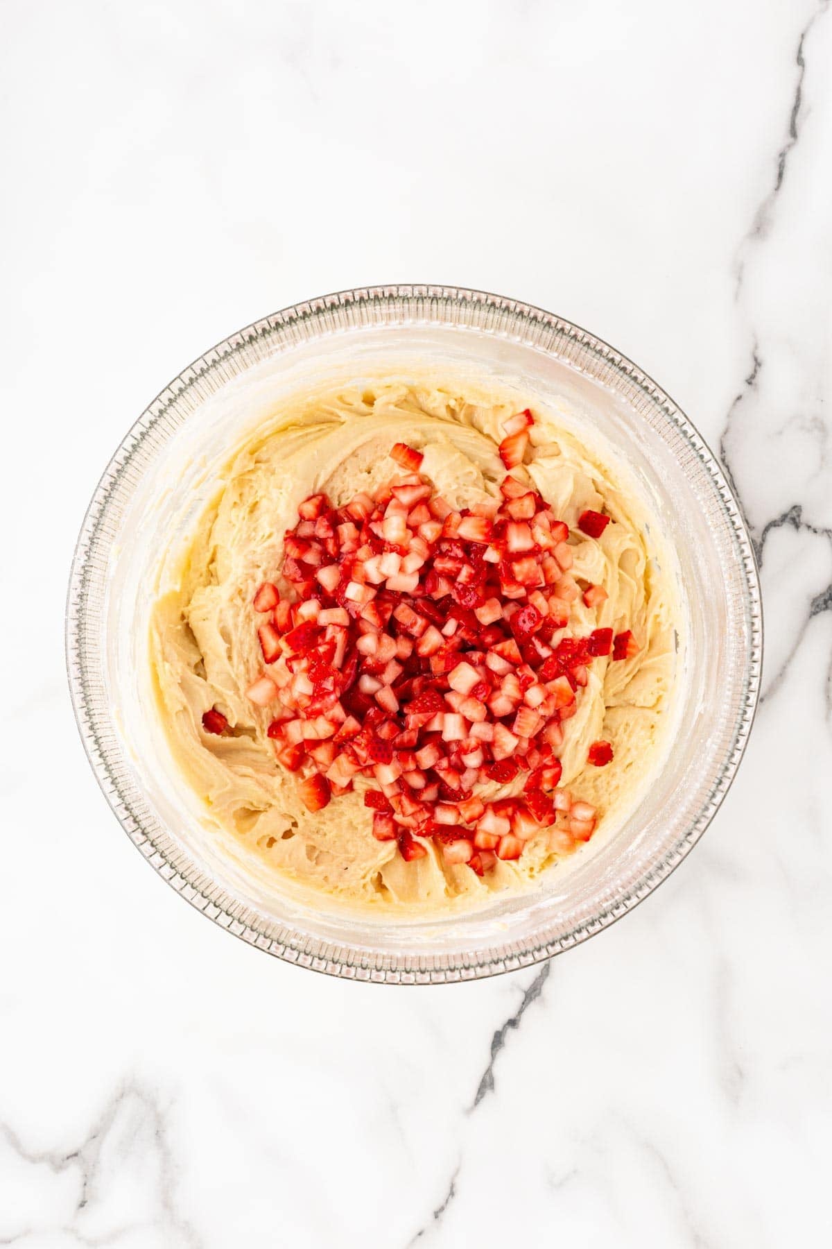 Strawberries folded into thick cake batter