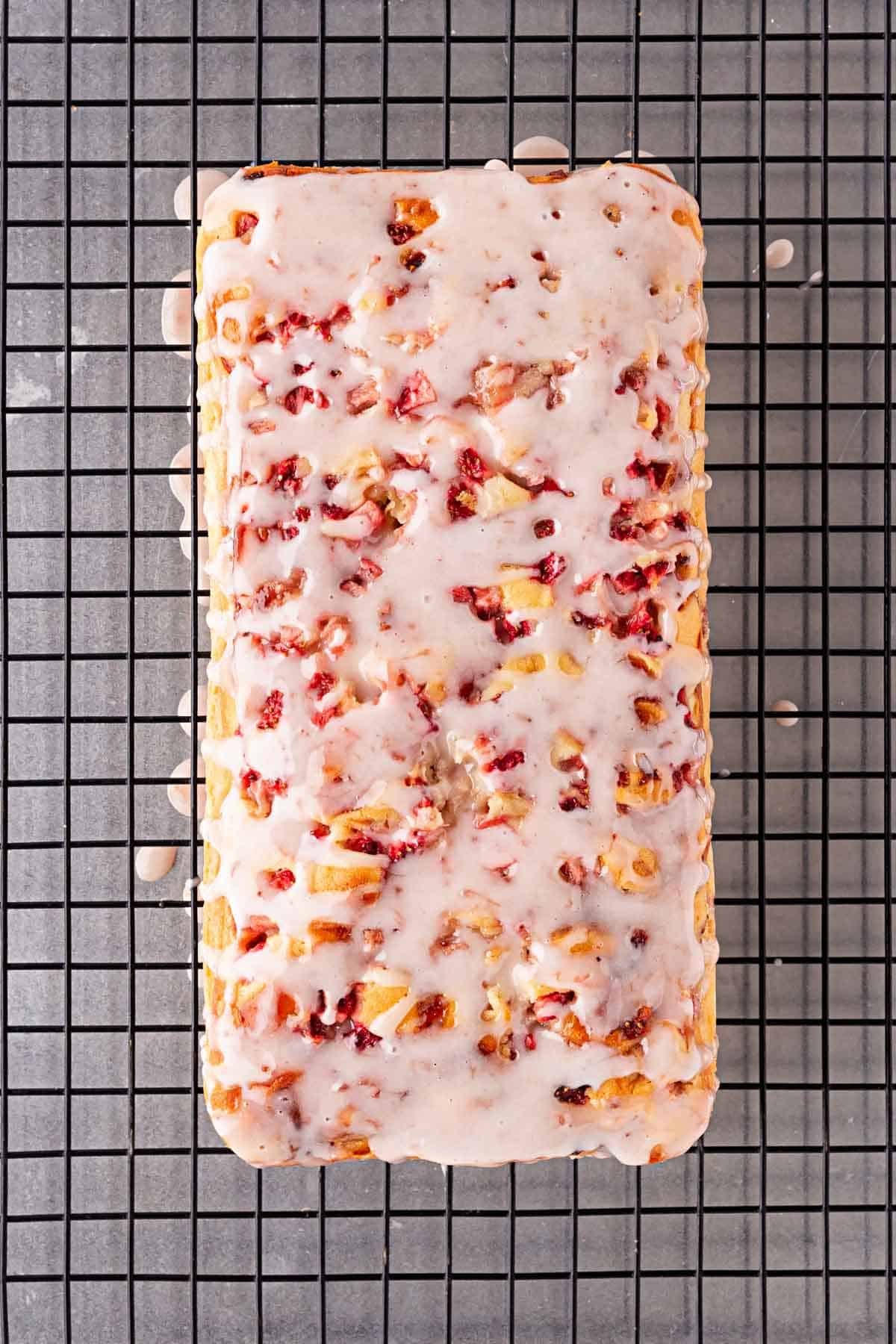 Glazed strawberry loaf cooling on wire rack