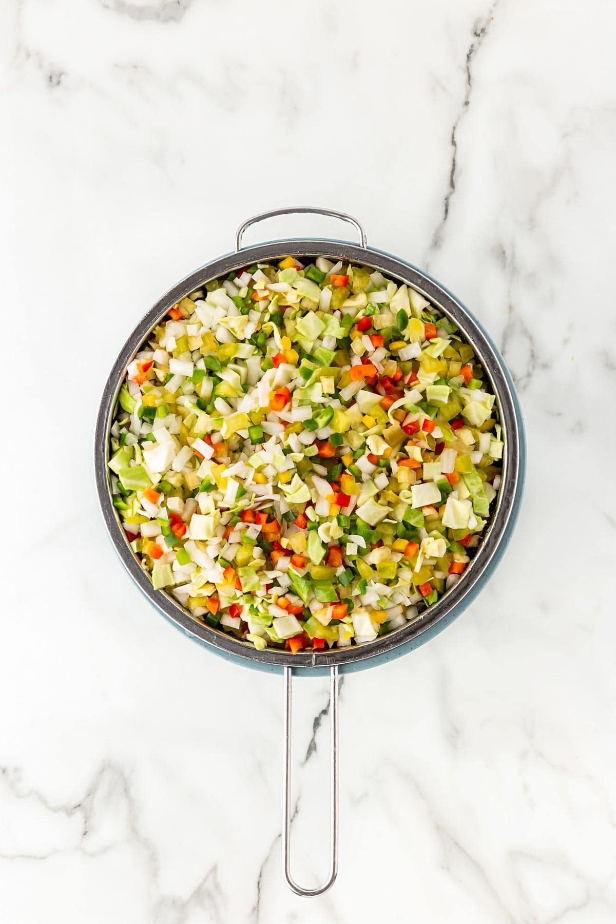 Chopped chow chow vegetables draining in a mesh strainer